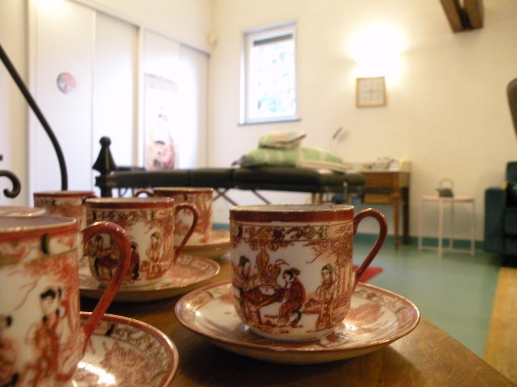 Vue du cabinet avec en fond la table de soin et en premier plan un service à café de Chine.