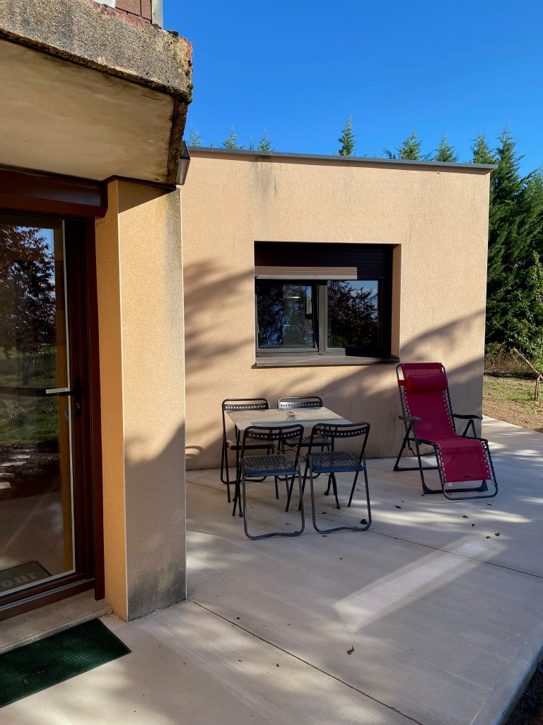 Terrasse avec une table de jardin, 4 chaises et un transat